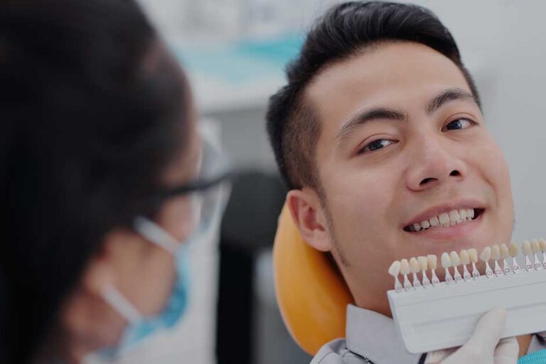 dentist bringing veneers pattern to patient