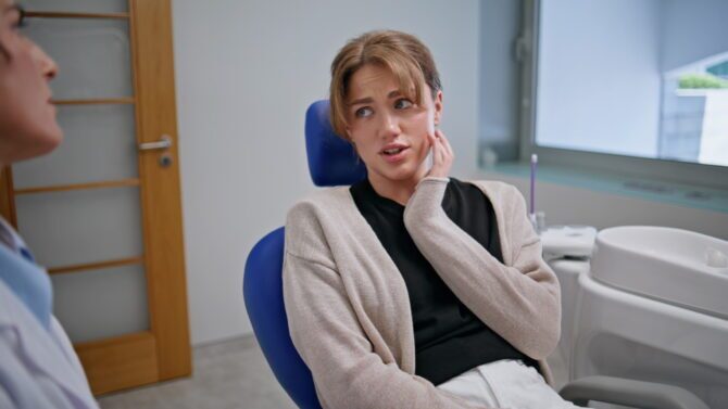 Patient experiencing jaw discomfort during a dental consultation