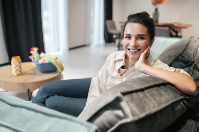 Smiling woman relaxing comfortably on a sofa at home
